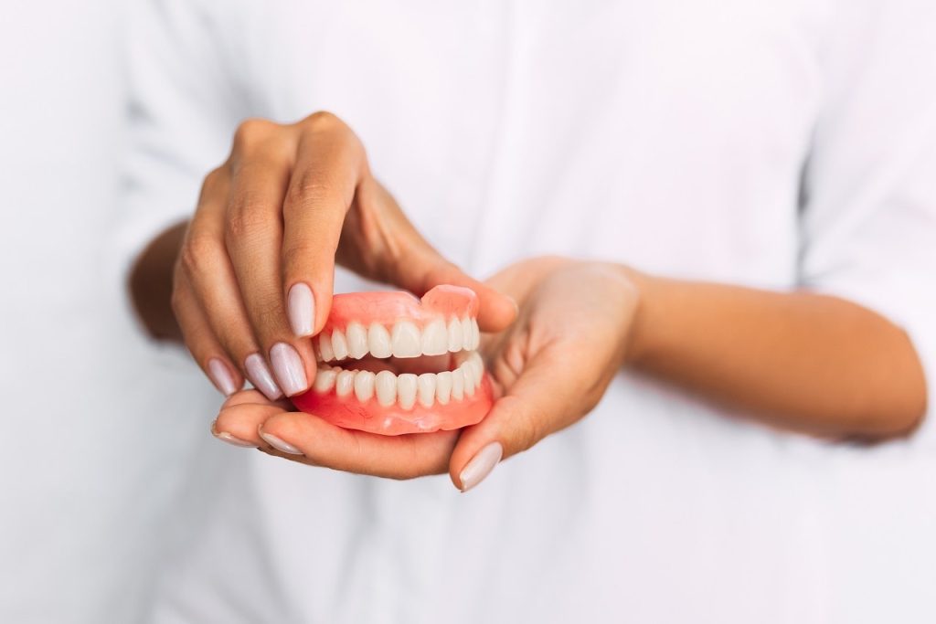 Denturist holding a set of full dentures