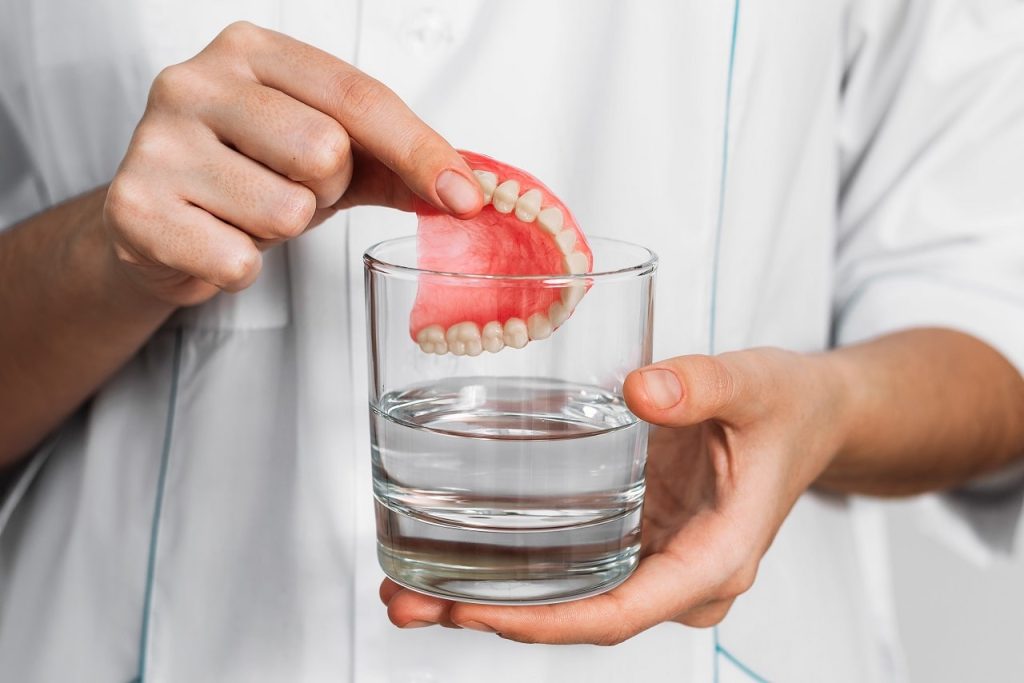 Suction Dentures being soaked in a glass of water
