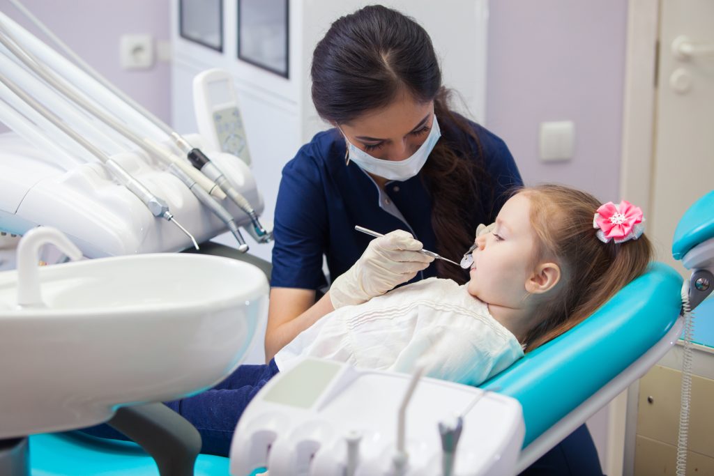 Little girl being examined by a female dentist