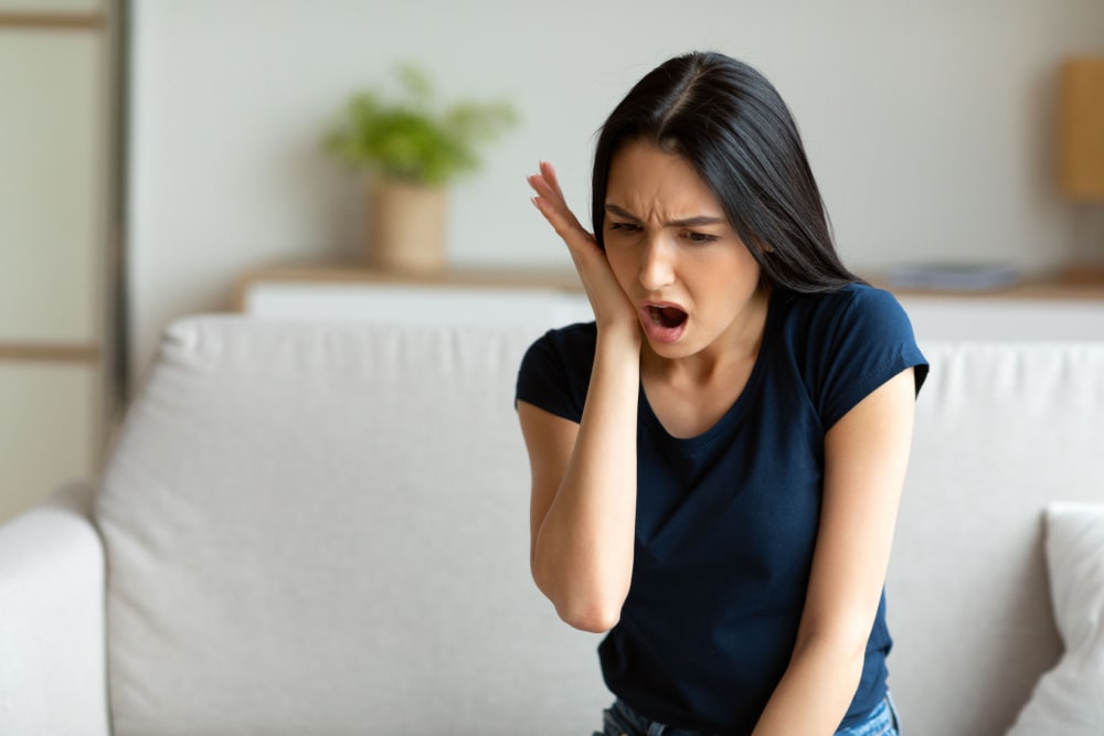 Woman in pain, suffering from extreme tooth ache