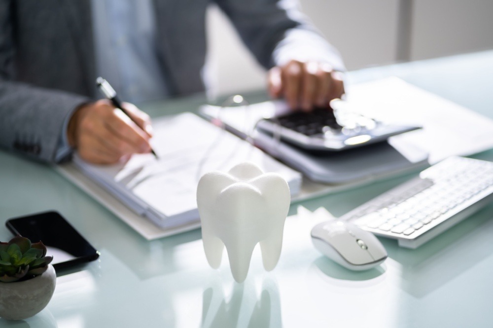 man calculating the cost of a dental cleaning